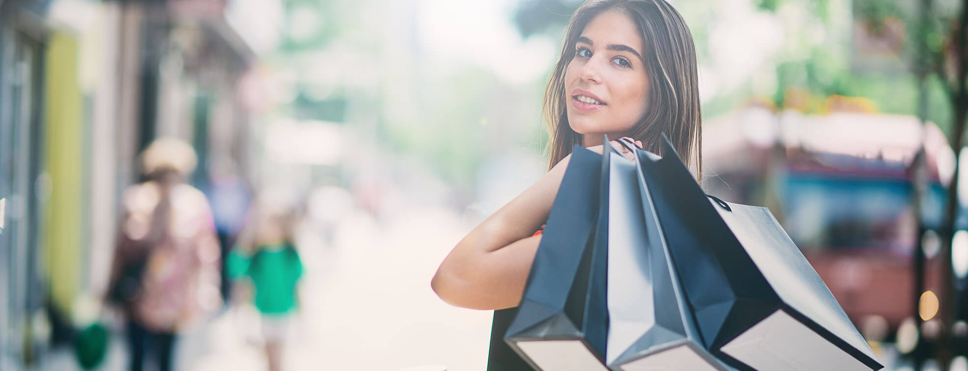 Girl with shopping bags walking out of a mall